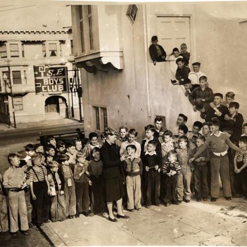 [Middle-age woman and boys outside one of San Francisco Boys' Club branches]