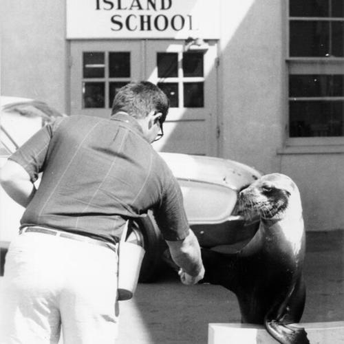 [Man with a trained seal visiting students at Treasure Island School]