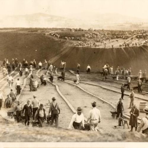 [Large group of men working on the construction of a new road around Lake Merced]