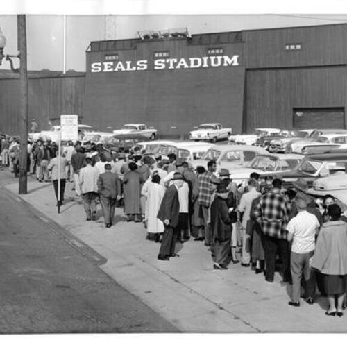 [Line of people on Sixteenth Street waiting to buy tickets for opening day game at Seals Stadium]