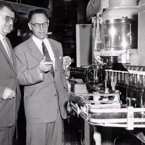 [Angelo Campodonico and Leo T. Englert looking over new bottle-caping equipment at Regal Pale Brewery]