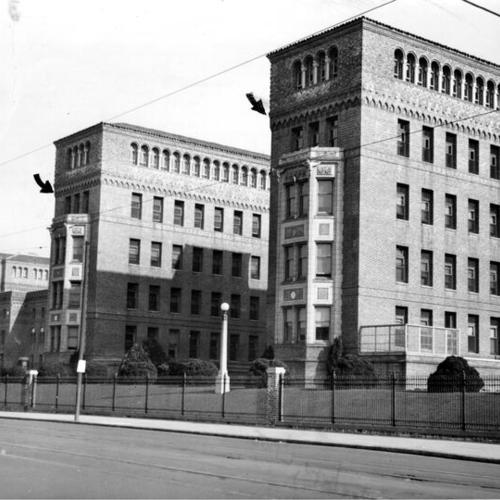 [Exterior view of San Francisco General Hospital with artist arrows added]