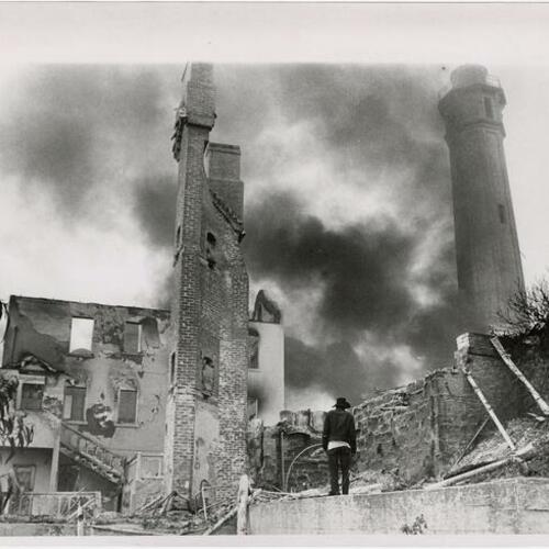 Person standing at ruins of five buildings destroyed by fire on Alcatraz