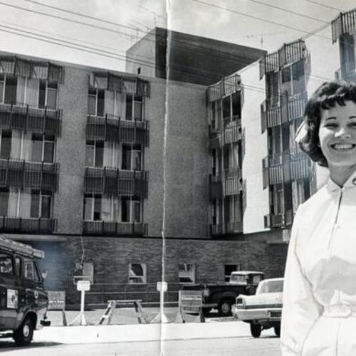 [Nurse Chris Henderson standing outside the new French Hospital building]