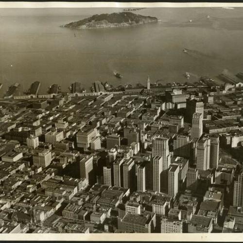 [Aerial view of the city and the Bay with Yerba Buena Island in the background]