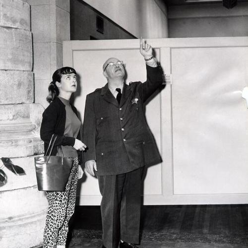 [Special policeman Clement Keller showing Mrs. Delight Schnieder why it is unsafe to enter the exhibition wing of the De Young Museum in Golden Gate Park]