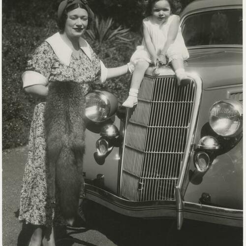 Mrs. George Hughson and daughter Gloria on top of a Ford automobile