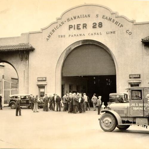[Group of men standing in front of the American-Hawaiian Steamship Company building at Pier 28]