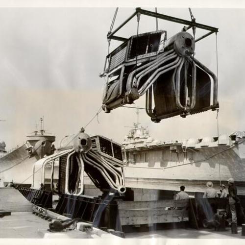[Condensers from the USS Independence being hoisted onto barge by the world's largest crane at San Francisco Naval Shipyard in Hunters Point]