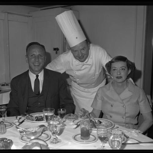 Bette Davis and people at Chef's table in St. Francis Hotel