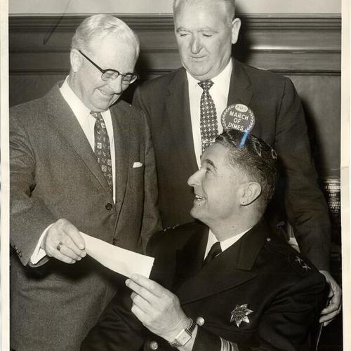 [Check is presented to J.P. Edwards, treasurer of the San Francisco Chapter of the National Foundation for Infantile Paralysis, by Police Chief Francis J. Ahern (seated), together with Officer James J. McGovern]
