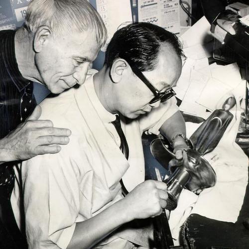 [Sculptor Beniamino Bufano and engraver Dick Leung working on a statuette of President Kennedy]