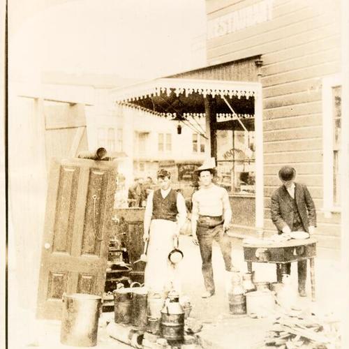 [Three men cooking on an unidentified street]