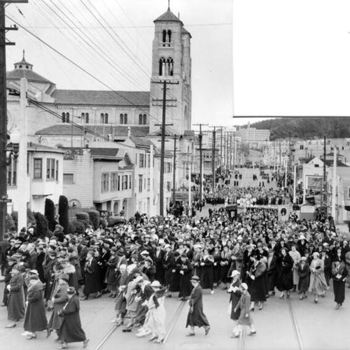 [Crowd of people marching in street during novena to St. Anne]