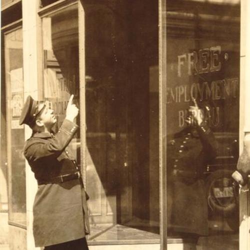 [Police pointing upward outside Free Employment Bureau during strikes of 1934]