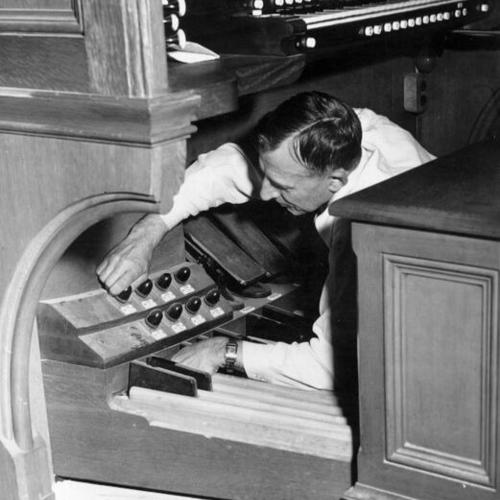 [Harry Richey works on organ at Grace Cathedral]