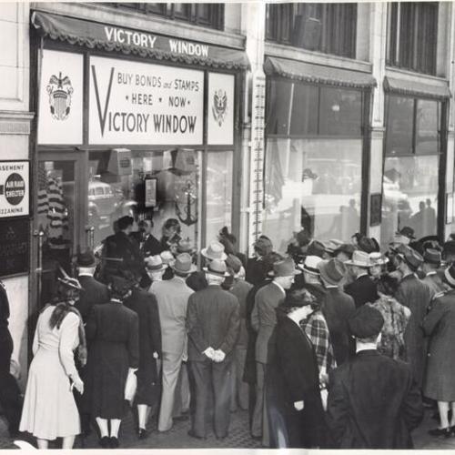 [Crowd gathered outside the "Victory Window" at I. Magnin]