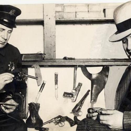 [Officer Walter Mitchell checking weapons with Terry Mullisack]