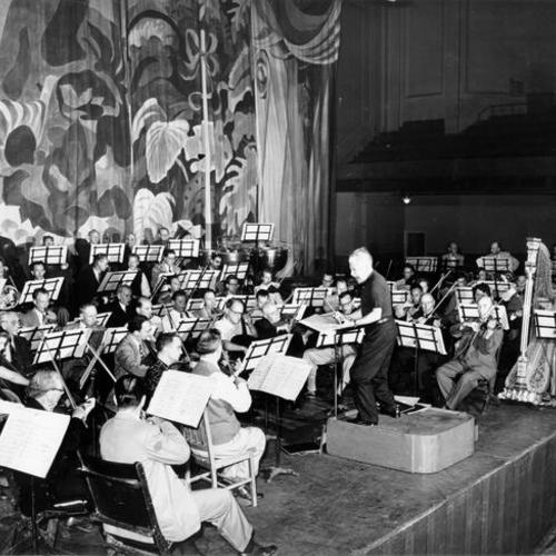 [Orchestra rehearsing at the Palace Hotel]
