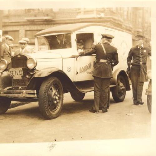 [Police officers inspecting motorist during strike of 1934]