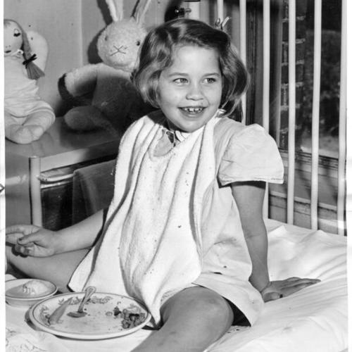 [Young girl at Shriners' Hospital for Crippled Children eating a meal]
