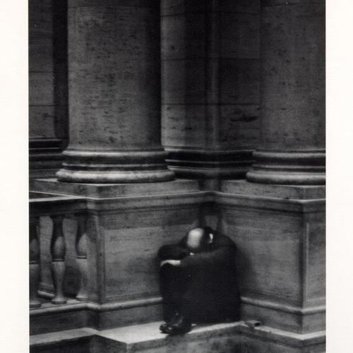 [Unidentified man sitting with his head resting in his arms on the staircase at the Main Library]