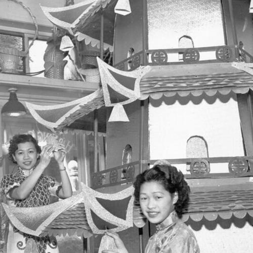 [Bertha Wong and Eva Woo preparing the float, which replicating an ancient Chinese bridge, for the opening day celebration parade of the San Francisco-Oakland Bay Bridge]