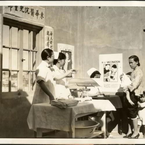 [Interior of Babies Aid Clinic in Chinese Hospital with Dr. Rose Goong Wong on far left and patients]