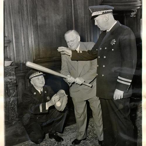 [Mayor Elmer E. Robinson playing baseball in his office at City Hall with Fire Chief Edward Walsh and Police Chief Michael Mitchell]