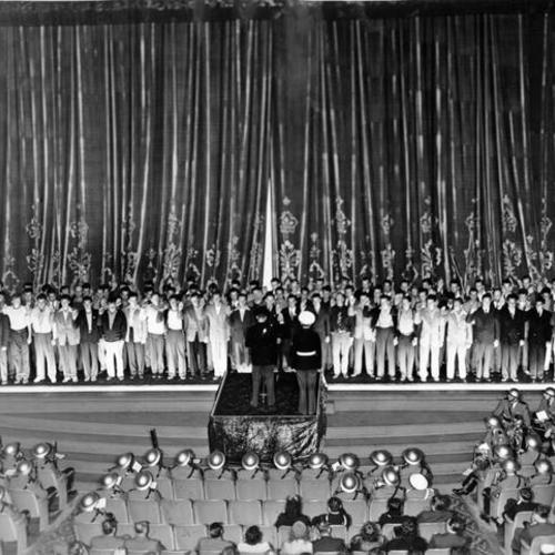 [Capt. Robert Payne administers the oath of enlistment to 80 young civilians who became marines on the Paramount stage]