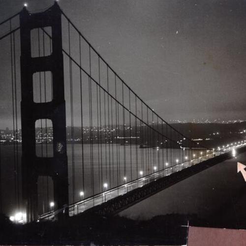 [Night view of Golden Gate Bridge with arrow pointing to foghorn]