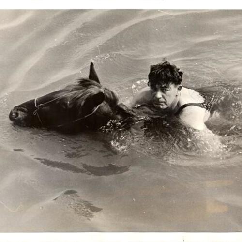 [Officer Daniel McSweeney swimming with Comanche]