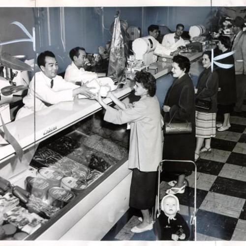 [Mrs. Bobbie Young making a purchase from Bob Wong at Wong's Meat Market]