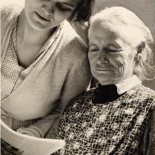 [Community Chest young woman reading the newspaper to an elderly woman]