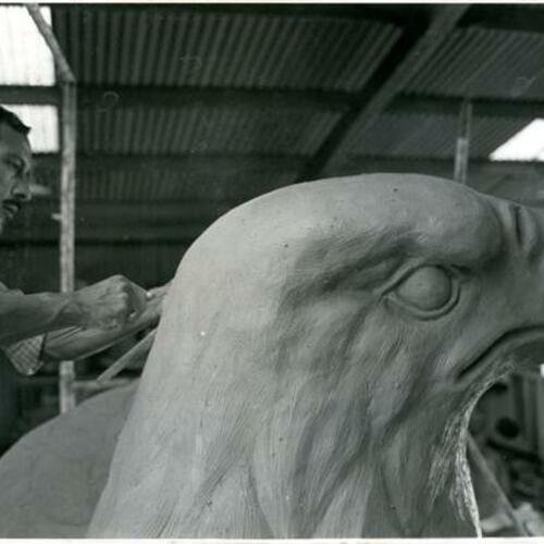 [Manuel Palos in his studio carving an eagle's head for Pacific Telephone Bell Building]