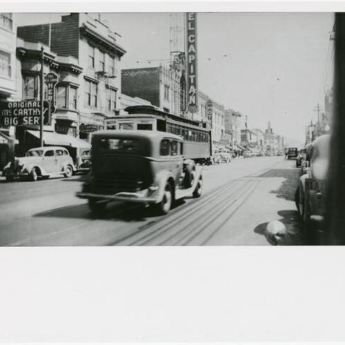  trolley and a car passing the El Capitan theater]