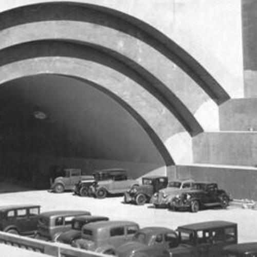 [View of automobiles parked at nearly completed Yerba Buena Island tunnel during San Francisco-Oakland Bay Bridge during construction]