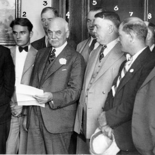 [Harry Bridges and other leaders of the maritime unions conferring with Mayor Rossi in his office]