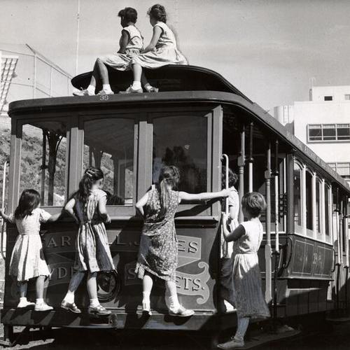 [Children playing on a cable car in the playground of the Youth Guidance Center]