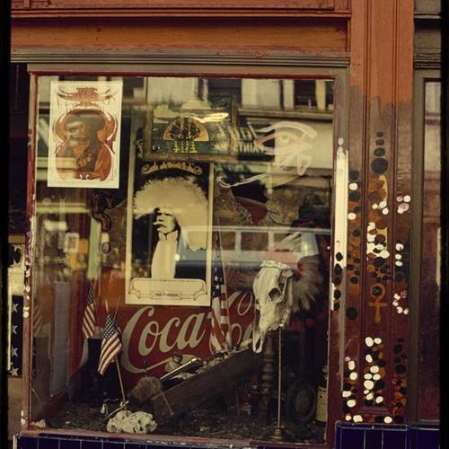 Storefront window decorated with paint and posters