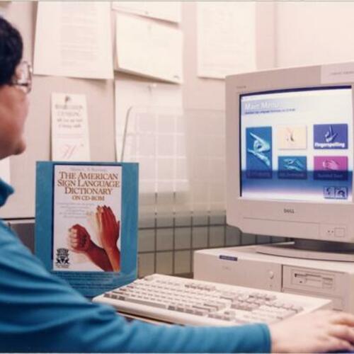 [Librarian Arden Wong uses the American Sign Language Dictionary on a computer]