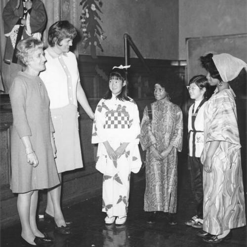 [Students in ethnic costumes celebrating Thanksgiving with principal from Andrew Jackson School and PTA Chairman at Lafayette School]