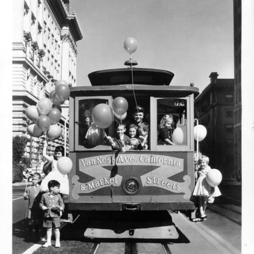 [Group of children with balloons on a California Street cable car]