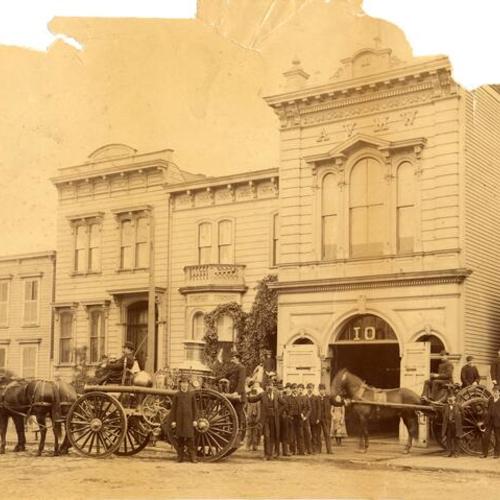 [Firemen with horsedrawn fire engines in front of the Old Engine 10 building]
