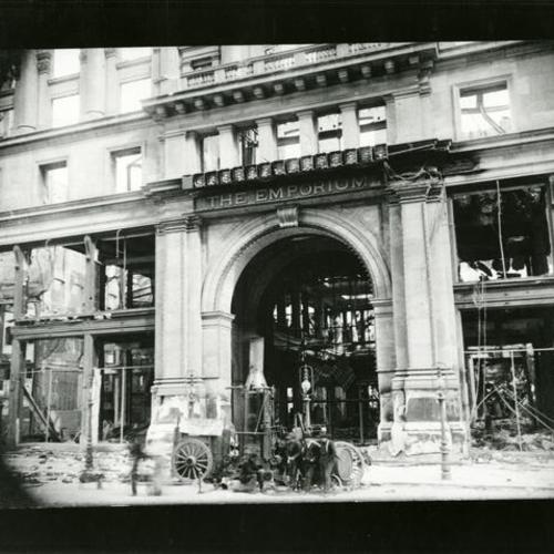 [Four people near the entrance to the burned out Emporium department store after the earthquake and fire of April 18, 1906]