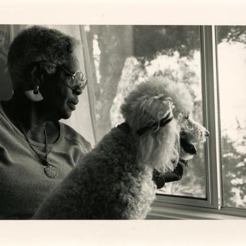 Senior with dog looking out window