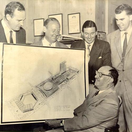[Benjamin H. Swig, hotelman and financier, posing with associates and sketch of plan for redevelopment of downtown city blocks]