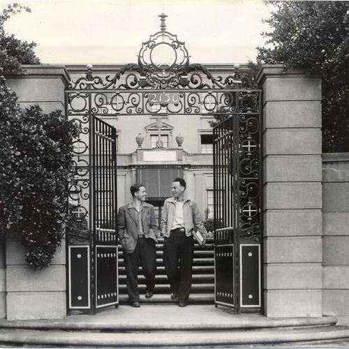 [Students Gene Dunn and Frank Ford walking through the main gate of the University of San Francisco]