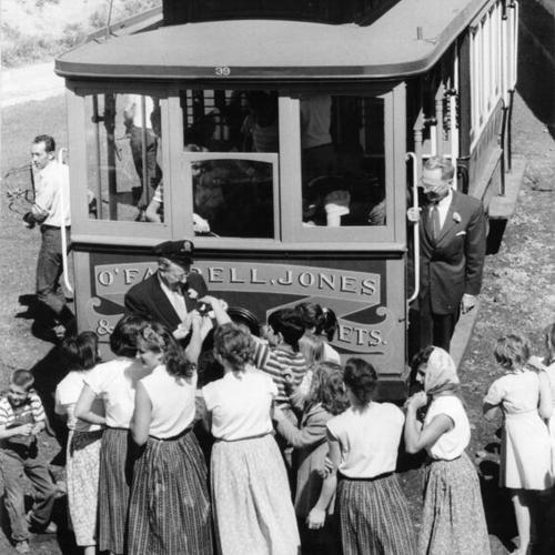 [Children at the Youth Guidance Center examining a cable car installed there for their amusement]