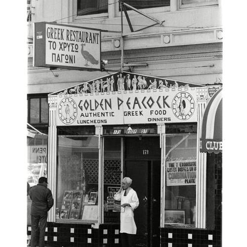 [Man standing outside of the Golden Peacock restaurant at 173 Eddy Street in the Tenderloin District]